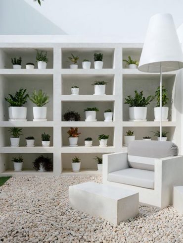 this-landscaped-outdoor-space-includes-a-living-room-with-a-bookshelf-for-plants