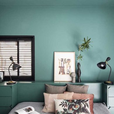 a-green-accent-wall-frames-the-bed-and-headboard-in-this-bedroom