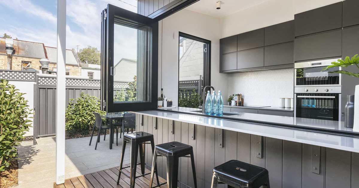 a-wall-of-bi-fold-windows-open-this-kitchen-to-the-outdoors
