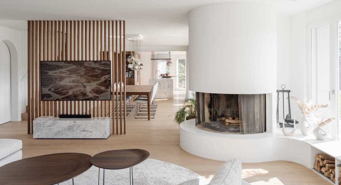 a-round-fireplace-is-a-unique-feature-in-the-living-room-of-this-remodeled-home