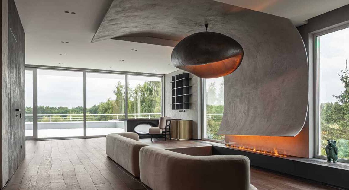 a-curved-accent-wall-wraps-around-from-the-fireplace-to-the-ceiling-inside-this-home