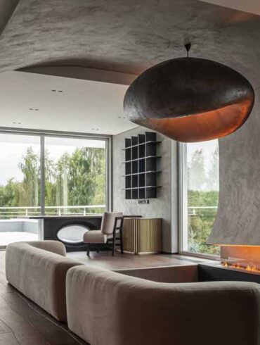 a-curved-accent-wall-wraps-around-from-the-fireplace-to-the-ceiling-inside-this-home