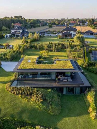 a-large-green-roof-covers-this-riverside-home