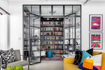 a-glass-enclosed-library-and-home-office-creates-a-separate-space-inside-this-apartment