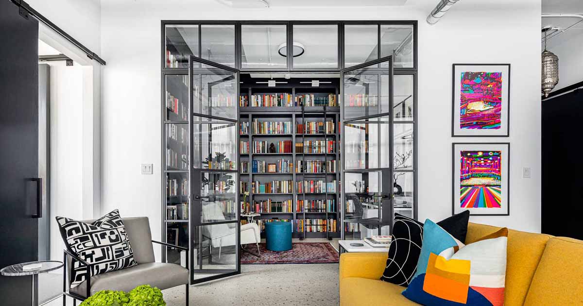 a-glass-enclosed-library-and-home-office-creates-a-separate-space-inside-this-apartment