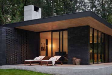 a-black-brick-exterior-is-consistent-with-the-dark-forest-surrounding-this-modern-home