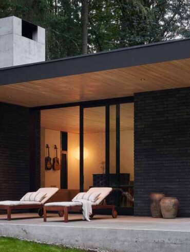 a-black-brick-exterior-is-consistent-with-the-dark-forest-surrounding-this-modern-home