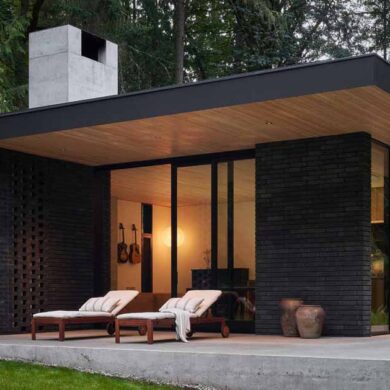 a-black-brick-exterior-is-consistent-with-the-dark-forest-surrounding-this-modern-home