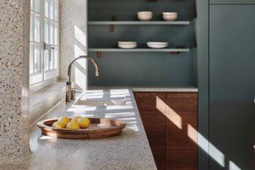 a-seamless-terrazzo-flows-from-the-wall-to-the-countertop-in-this-kitchen