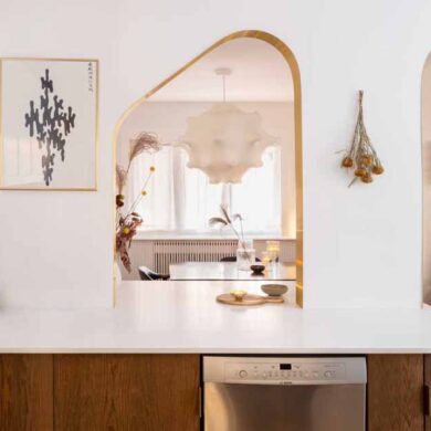 brass-lined-arches-connect-the-kitchen-with-the-dining-room-inside-this-home