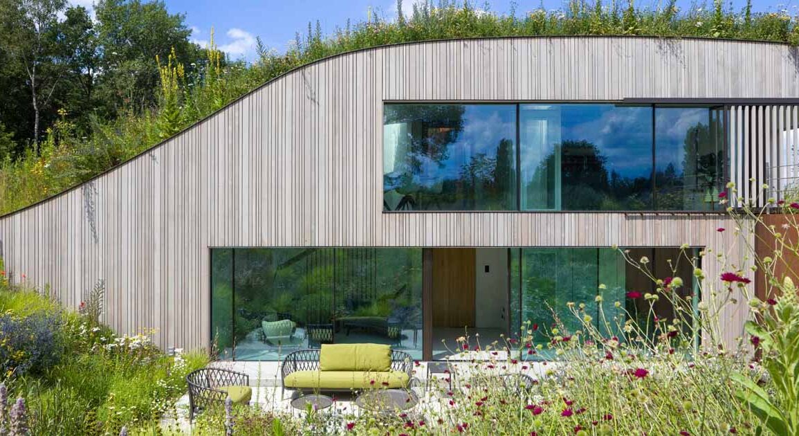 a-house-built-into-the-ground-and-covered-in-flowers