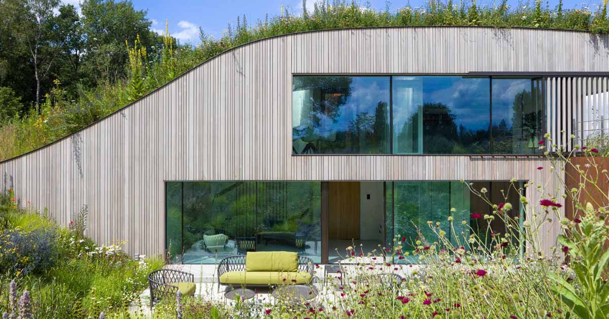 a-house-built-into-the-ground-and-covered-in-flowers