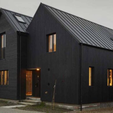 the-black-exterior-of-this-home-leads-to-a-pink-kitchen-inside