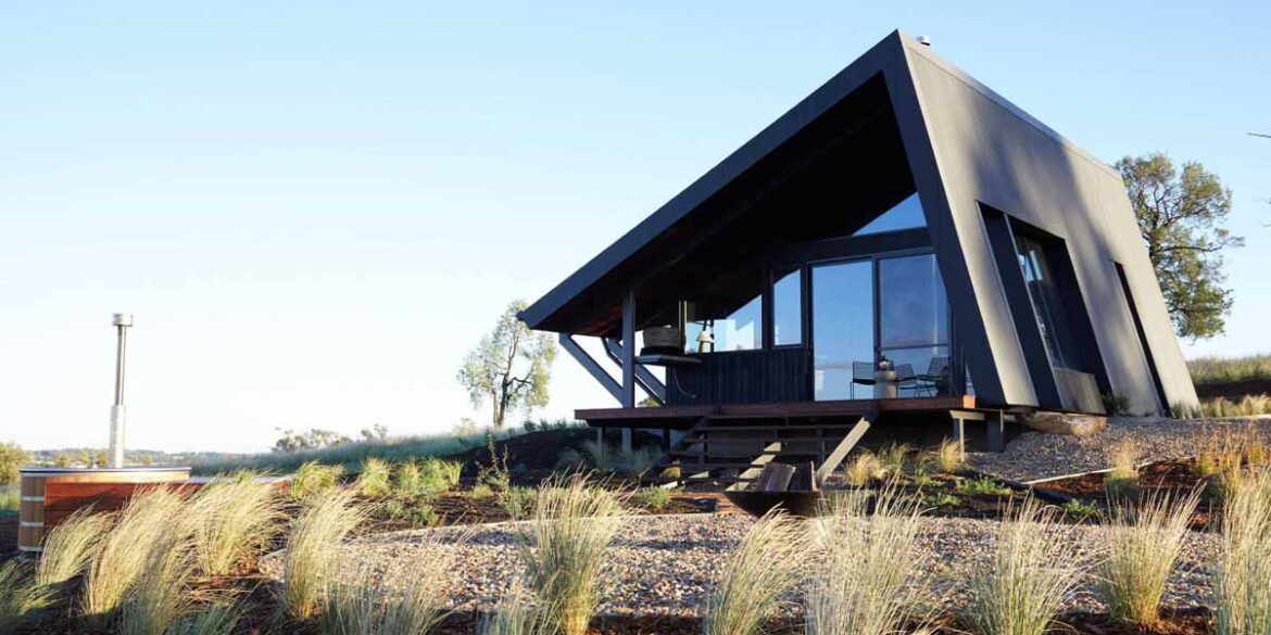 a-metal-roof-wraps-around-this-off-grid-cabin-to-protect-it-from-the-elements