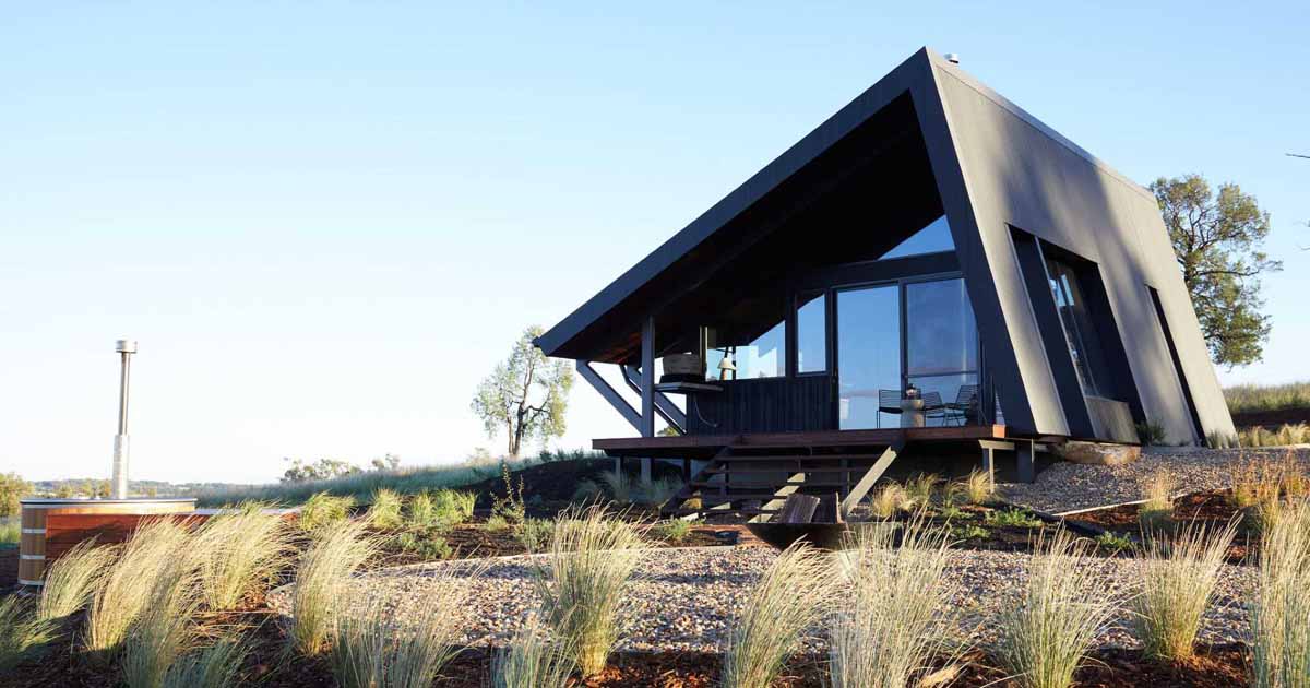 a-metal-roof-wraps-around-this-off-grid-cabin-to-protect-it-from-the-elements