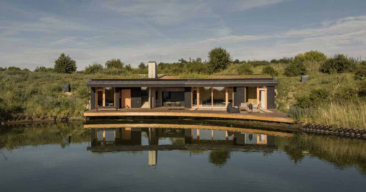 this-small-home-with-a-green-roof-curves-around-a-pond