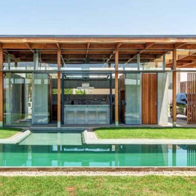 an-exposed-structure-shows-off-this-house-design-that-wraps-around-a-pool