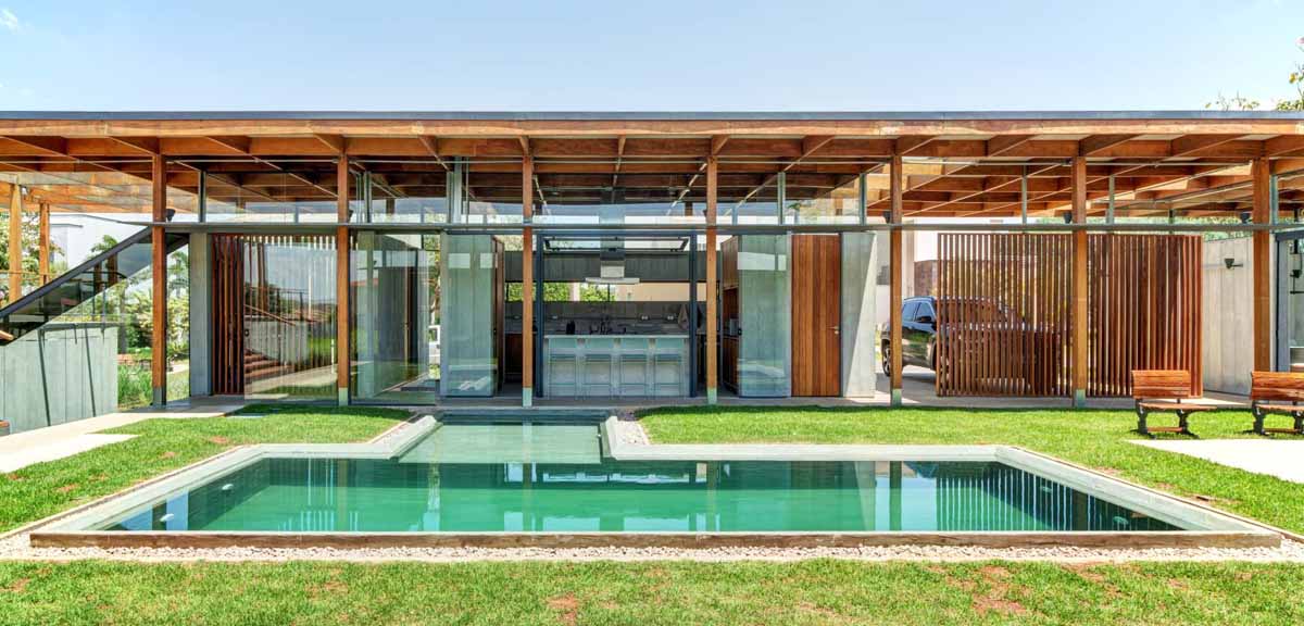 an-exposed-structure-shows-off-this-house-design-that-wraps-around-a-pool