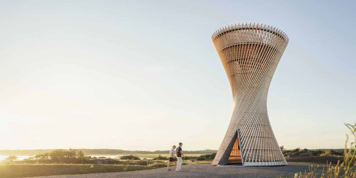 an-observation-tower-that-looks-like-twisted-wood-rises-above-the-swedish-landscape