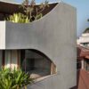 a-curvy-concrete-cube-with-cut-outs-for-windows-is-the-form-of-this-new-home