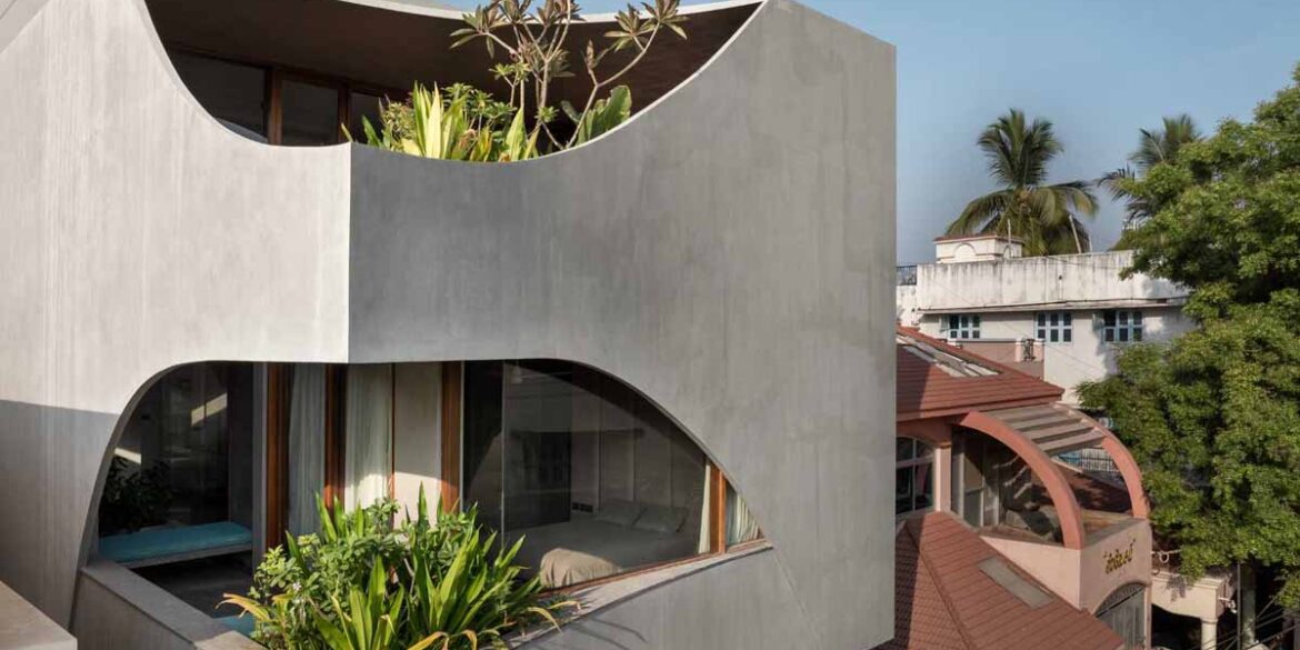 a-curvy-concrete-cube-with-cut-outs-for-windows-is-the-form-of-this-new-home