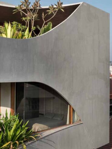 a-curvy-concrete-cube-with-cut-outs-for-windows-is-the-form-of-this-new-home