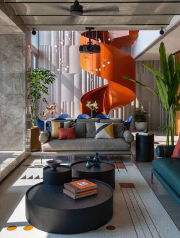 an-orange-spiral-staircase-is-an-eye-catching-feature-inside-this-apartment