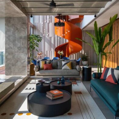 an-orange-spiral-staircase-is-an-eye-catching-feature-inside-this-apartment