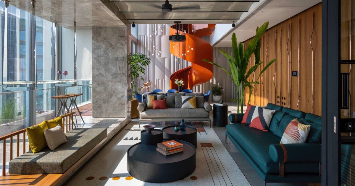 an-orange-spiral-staircase-is-an-eye-catching-feature-inside-this-apartment